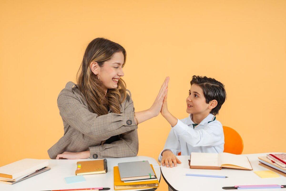 Schulbegleiterin und Kind geben sich im Unterricht ein High-Five – Integrationshilfe im Kreis Recklinghausen